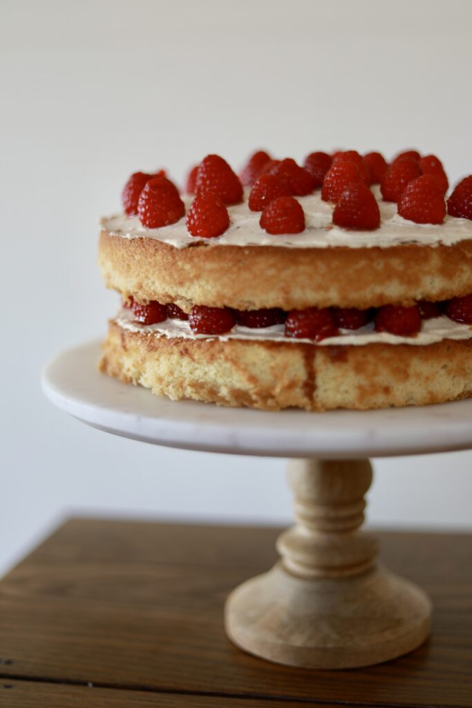 Delicious yellow cake with raspberries on a cake stand